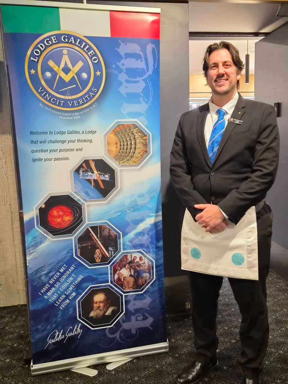 A brother beside the Lodge Galileo banner